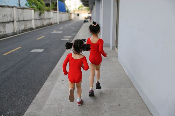 Ученицы бегут в уборные во время перерыва между занятиями в спортивной олимпийской школе. Шанхай, Китай