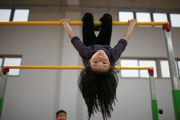 Девочка во время занятий в олимпийской спортивной школе. Шанхай, Китай