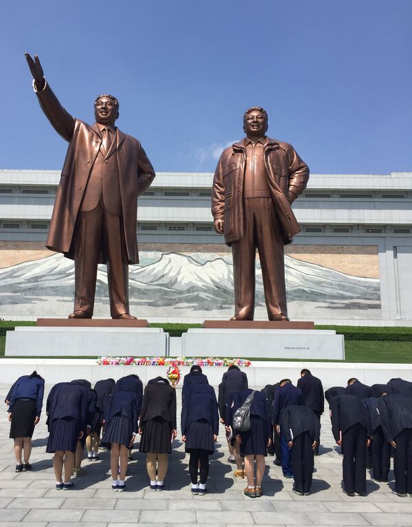 Граждане Северной Кореи во время посещения монумента Ким Ир Сену и Ким Чен Иру в центре Пхеньяна