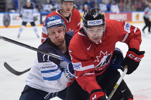 Игрок сборной Финляндии Леонид Комаров (слева) и игрок сборной Канады Коди Сеси в финальном матче чемпионата мира по хоккею между сборными командами Финляндии и Канады
