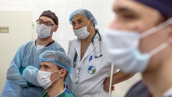 Хирурги смотрят за ходом операции при помощи робота Да Винчи. Архивное фото