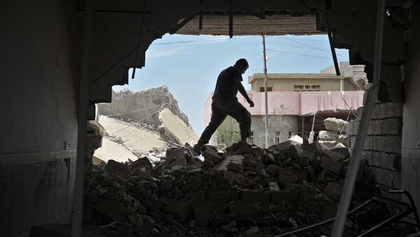 Местный житель осматривает развалины своего дома в Ираке. Архивное фото