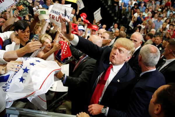 Кандидат в президенты США Дональд Трамп раздает автографы после митинга со своими сторонниками в Альбукерке, США. Май 2016