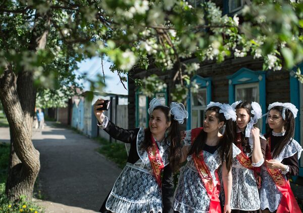 Выпускницы фотографируются во время праздника Последний звонок в гимназии №1 им. А.Лупова в городе Тара Омской области