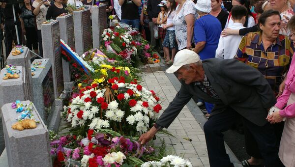 Люди возлагают цветы на церемонии открытия мемориала, установленного в память о жителях Куйбышевского района Донецка и посёлка Весёлый, погибших в результате боевых действий 2014-2016 годов