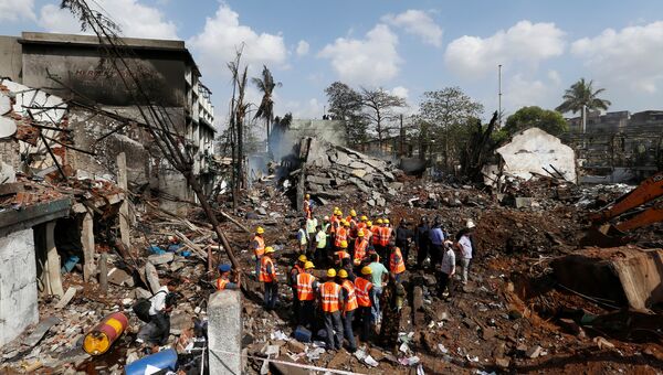 Спасатели работают на месте взрыва на химическом заводе в промышленной зоне на окраине Мумбаи