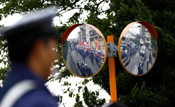 Отражение протестующих в зеркалах во время саммита G7 в городе Цу, Япония. 26 мая 2016 года