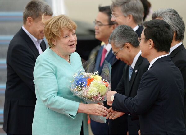 Канцлер Германии Ангела Меркель и ее муж во время прибытия в Международный аэропорт Чубу Центрэй, Япония. 26 мая 2016