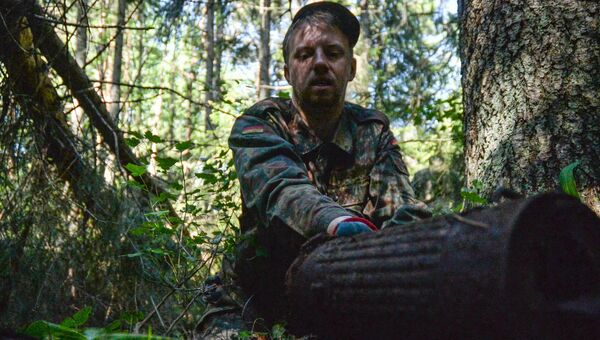 Сотрудник Немецкого Союза Дмитрий Волков извлекает предметы истлевшей военной амуниции из финского блиндажа.