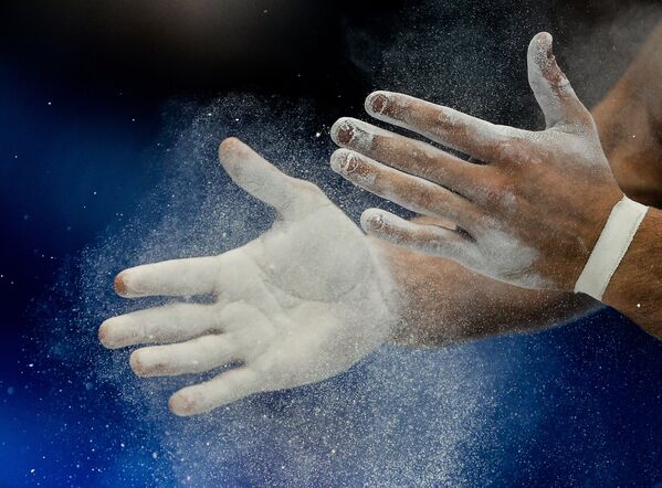 Руки гимнаста перед выполнением упражнений на брусьях в командном первенстве среди мужчин на чемпионате Европы по спортивной гимнастике в Берне