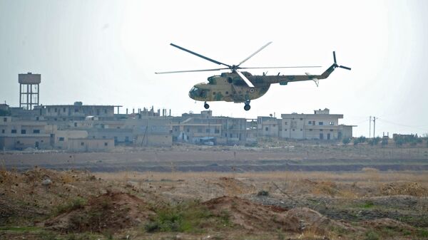 Вертолет сирийских ВВС совершает облет авиабазы Хама в пригороде города Хама сирийской провинции Хама