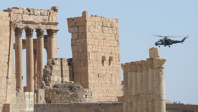 Вертолет ВКС РФ в небе над исторической частью Пальмиры. Архивное фото