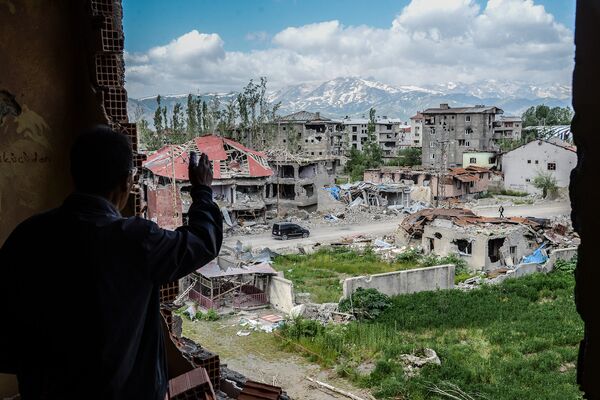 Поврежденные в результате боев между войсками Турции и курдскими боевиками здания в городе Юксекова, май 2016