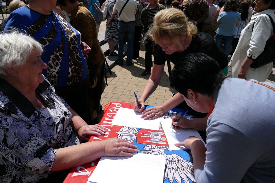 Жительница Донецка во время митинга подписывает петицию против нарушения Киевом резолюции Совета Безопасности ООН