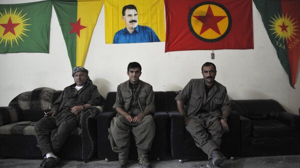 Бойцы Рабочей партии Курдистана (РПК) под портретом Абдуллы Оджалана и флагами РПК и JPG. Архивное фото