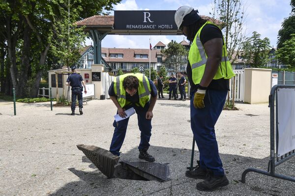 Проверка канализационных коммуникаций сотрудниками службы безопасности рядом с отелем Ренессанс в пригороде Парижа Рюэль-Мальмезон