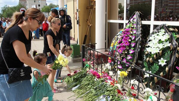 Местные жители возлагают цветы на месте гибели продавца оружейного магазина Паллада Андрея Максименко в Актобе, Казахстан. 8 июня 2016