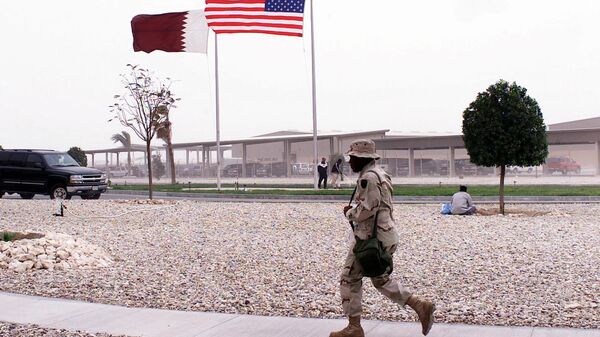 Американский военный на фоне флагов США и Катара