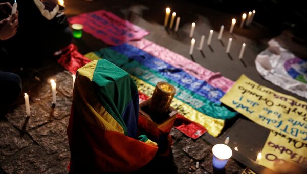 Флаги и свечи в память о погибших в гей-клубе в Орландо