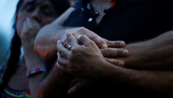 Люди держатся за руки после стрельбы в гей-клубе в Орландо. Архивное фото