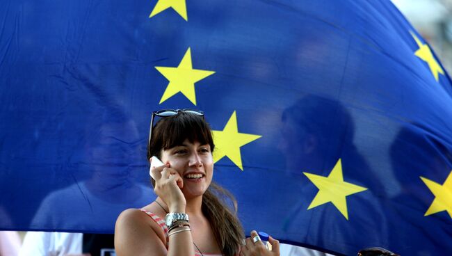 Жительница Афин на фоне флага Евросоюза, Греция. Архивное фото