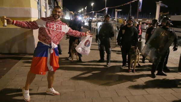 Российский болельщик возле полицейских на одной из улиц Марселя после окончания матча между сборными командами Англии и России