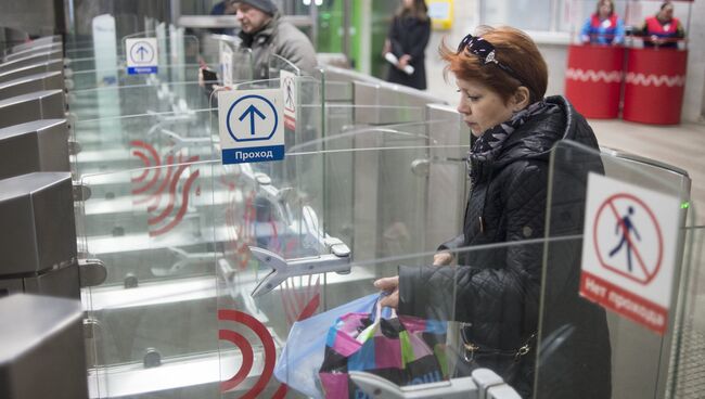 Пассажиры проходят турникеты в вестибюле станции метро. Архивное фото
