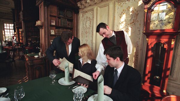 Официант обслуживает посетителей в ресторане Пушкин. Архивное фото