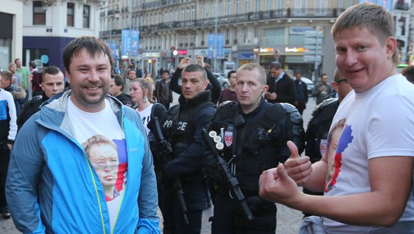 Сотрудники полиции и российские болельщики на одной из улиц во французском городе Лилле