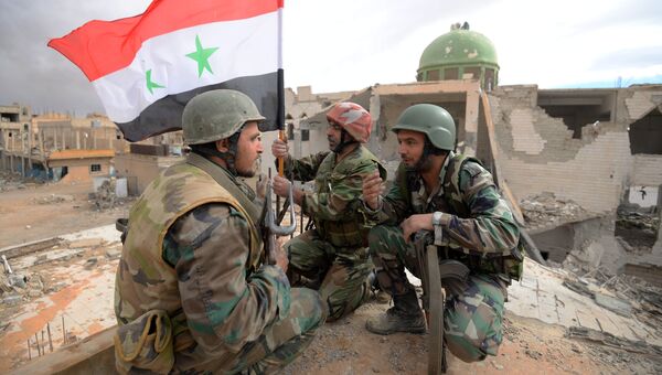 Солдаты сирийской армии (САА) с флагом Сирии радуются освобождению Пальмиры. Архивное фото