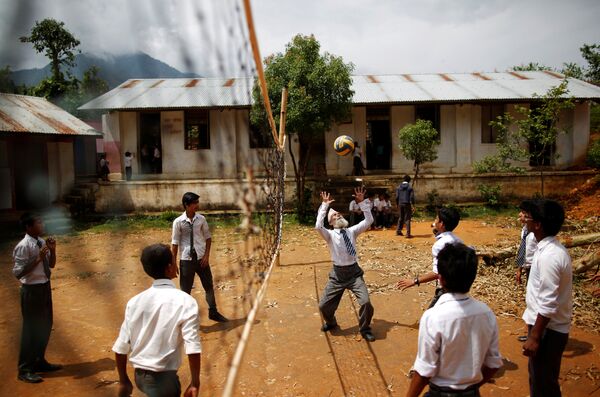 Дурга Ками 68-летний студент высшей средней школы играет в волейбол во время перемены, Непал