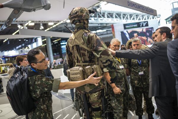 Посетители осматривают военную форму на одном из стендов на международной выставке вооружений EUROSATORY