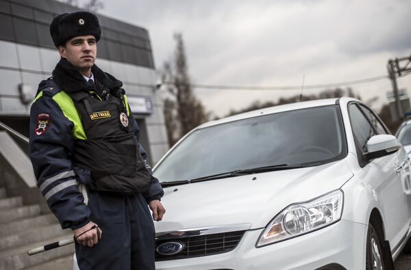 Сотрудник ГИБДД рядом с автомобилем без специальных знаков и проблескового маячка во время рейда скрытых патрулей ДПС в Москве