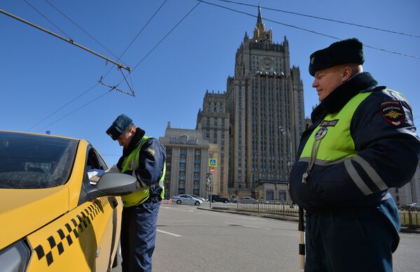 Сотрудники ГИБДД проверяют документы у водителя в рамках рейда против нелегальных таксистов в Москве