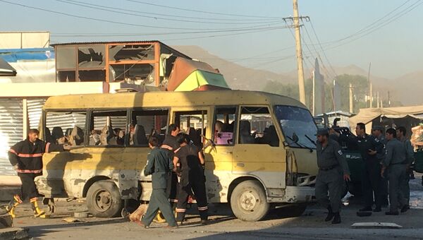 Полицейские и пожарные на месте взрыва микроавтобуса в Кабуле. Афганистан