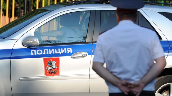 Полицейский автомобиль и сотрудник полиции в Москве