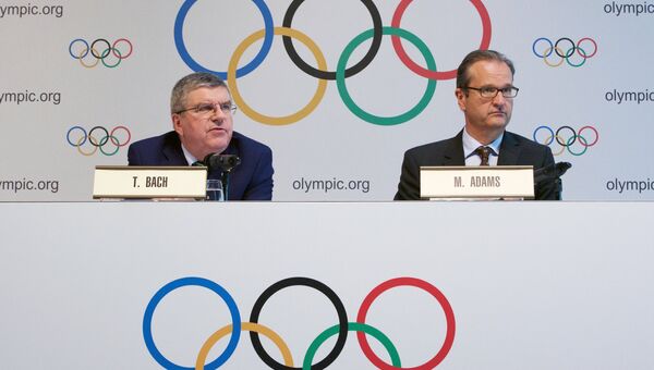 Президент МОК Томас Бах и директор по коммуникациям Марк Адамс на пресс-конференции по итогам специального заседания Международного олимпийского комитета в Лозанне. 21 июня 2016