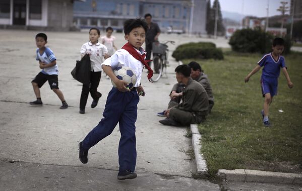 Школьники играют в футбол в Северной Корее. 21 июня 2016