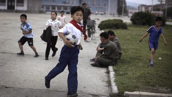 Школьники играют в футбол в Северной Корее. 21 июня 2016