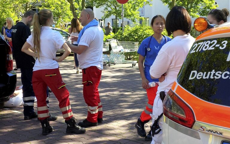 Медработники у здания кинотеатра в немецком Фирнхайме, где произошла стрельба