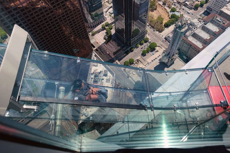 Женщина скользит вниз по Skyslide на внешней стороне Bank Tower в Лос-Анджелесе, США. Июнь 2016