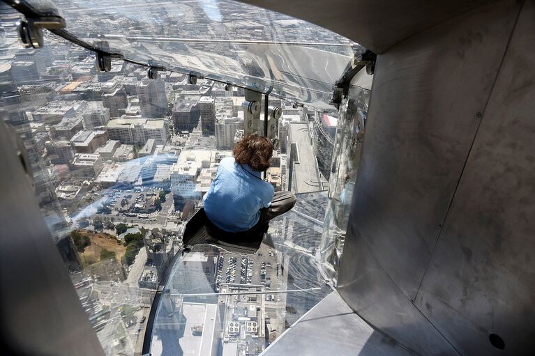 Женщина скользит вниз по Skyslide на внешней стороне Bank Tower в Лос-Анджелесе, США. Июнь 2016