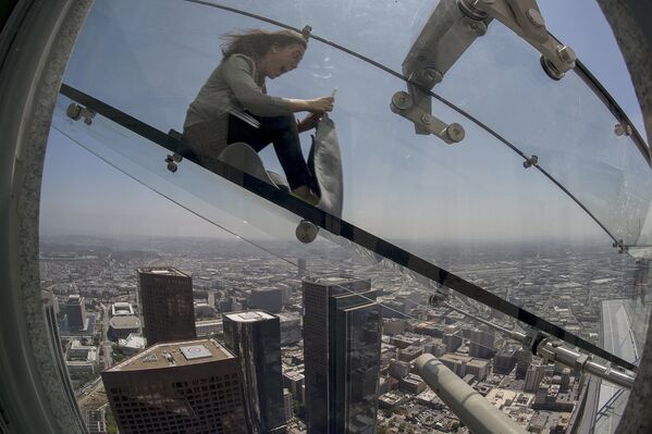 Женщина скользит вниз по Skyslide на внешней стороне Bank Tower в Лос-Анджелесе, США. Июнь 2016