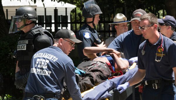 Пострадавшего в демонстрациях неонацистов в Сакраменто уносят на носилках. Калифорния