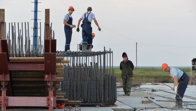 Рабочие собирают опалубку под опору моста, строящегося через Керченский пролив в Крыму. 23 июня 2016