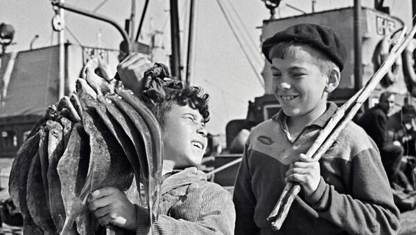 Юный рыболов из колхоза им. Ленина на Камчатке демонстрирует товарищу богатый улов