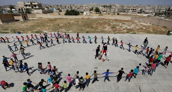 Ученики водят хоровод по случаю празднования конца учебного года в школе в провинции Идлиб. Сирия, 1 июня 2016