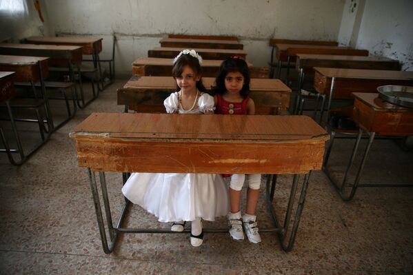 Девочки сидят за партой в одной из школ в Дамаске. Сирия, 21 мая 2016