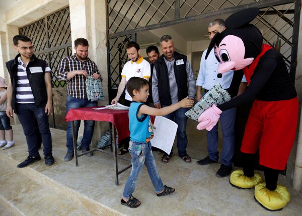 Ученики получают сертификаты и подарки в конце учебного года в школе в провинции Идлиб. Сирия, 1 июня 2016