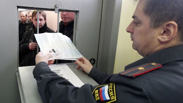Инспектор ГИБДД принимает документы от водителя на одном из московских пунктов техосмотра автомобилей. Архивное фото